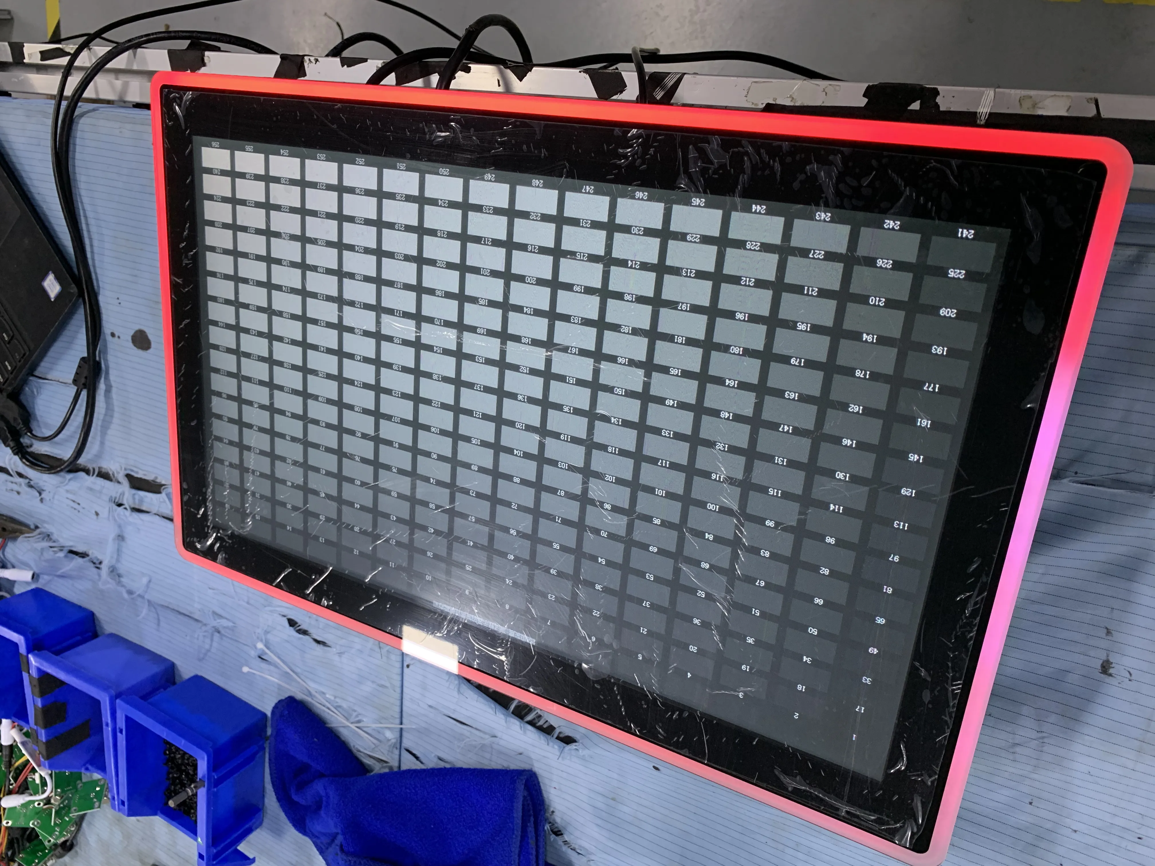 32-inch touchscreen kiosk display undergoing environmental testing in various lighting conditions showing brightness optimization and anti-glare performance